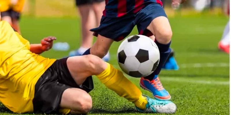 Thực hiện động tác xoạc bóng chính xác trên sân cỏ